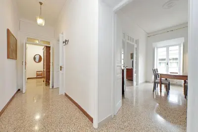a white hallway with a table and a dining room at suity I cozy belli apartment in Rome