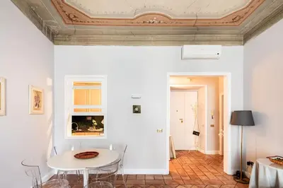 a white room with a table and chairs and a ceiling at Domus Paolina Arenula in Rome