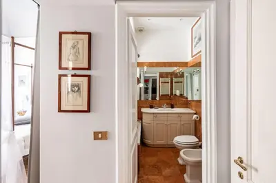 a bathroom with a toilet and a sink and a mirror at Domus Paolina Arenula in Rome