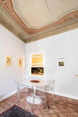 a table and chairs in a room with a ceiling at Domus Paolina Arenula in Rome