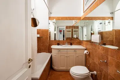 a bathroom with a toilet and a sink and a tub at Domus Paolina Arenula in Rome