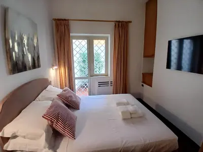 a bedroom with a bed with white sheets and a window at Elizabeth's Place Spanish Steps in Rome