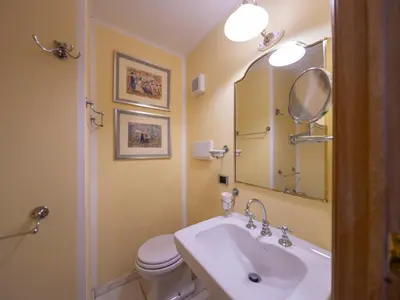 a bathroom with a sink and a toilet and a mirror at Elizabeth's Place Spanish Steps in Rome
