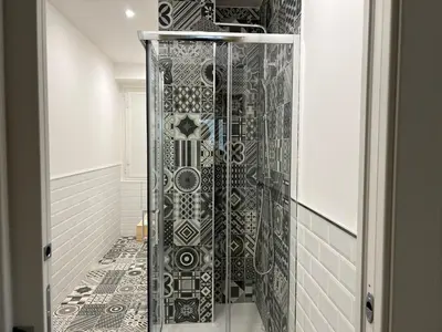 a shower with a glass door in a bathroom at Roma Furio Camillo Holiday Home in Rome