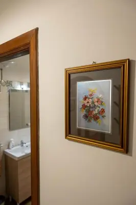 a bathroom with a painting of flowers on the wall at Casa vacanze Holly in Rome