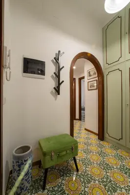 a room with a green ottoman sitting on a tile floor at Casa vacanze Holly in Rome
