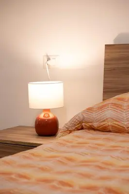 a lamp sitting on a table next to a bed at Casa vacanze Holly in Rome