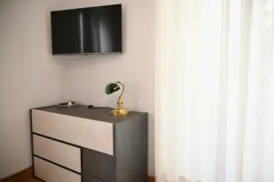 a lamp on a dresser with a television on a wall at Mirabilia Suites Colosseum in Rome