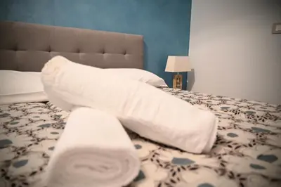 a bed with white pillows and towels on it at Mirabilia Suites Colosseum in Rome