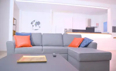 a living room with a couch with orange and blue pillows at Toscani 24 in Rome
