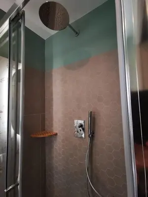 a bathroom with a shower with brown tiles at Apuleio 11 in Rome