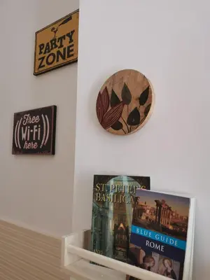 a shelf with books and a clock on a wall at Apuleio 11 in Rome