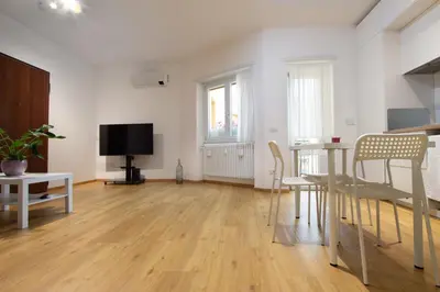 a living room with a table and chairs and a tv at Cozy Vatican in Rome