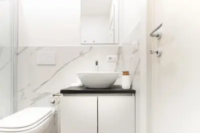 a white bathroom with a sink and a toilet at Cozy Vatican in Rome