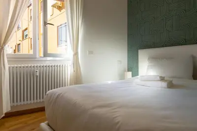 a bedroom with a large white bed with a window at Cozy Vatican in Rome