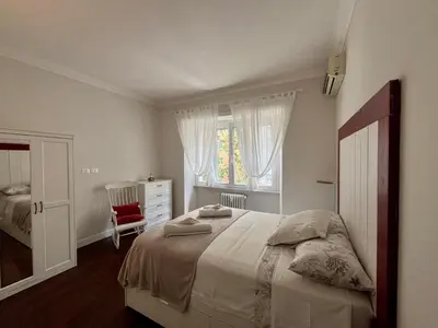 a white bedroom with a bed and a window at Vatican Family House 2 Baths & 3 Rooms in Rome