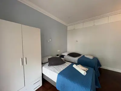 a bedroom with two beds and a cabinet at Vatican Family House 2 Baths & 3 Rooms in Rome