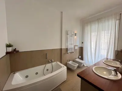 a bathroom with a large tub and two sinks at Vatican Family House 2 Baths & 3 Rooms in Rome