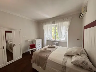 a white bedroom with a bed and a window at Vatican Family House 2 Baths & 3 Rooms in Rome