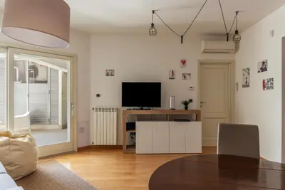 a living room with a television and a table at GuestHost - Porta Portese Modern Terrace Apartment in Rome