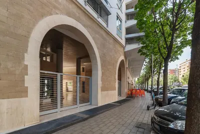 an archway on a building with cars parked on a sidewalk at GuestHost - Porta Portese Modern Terrace Apartment in Rome