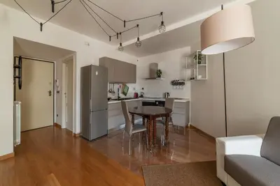 a kitchen and living room with a table and a couch at GuestHost - Porta Portese Modern Terrace Apartment in Rome