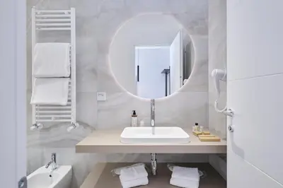 a white bathroom with a sink and a mirror at San Giovanni Retreat in Rome