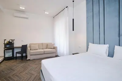 a bedroom with a white bed and a chair at San Giovanni Retreat in Rome