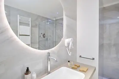 a white bathroom with a sink and a mirror at San Giovanni Retreat in Rome