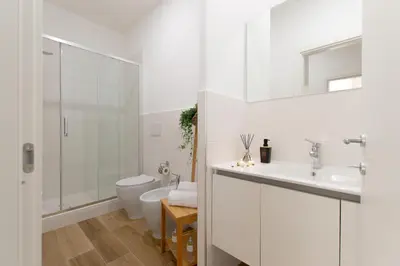 a white bathroom with a toilet and a sink at Casa Coppedè in Rome