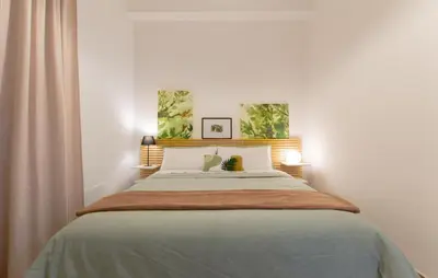 a bedroom with a large bed with two paintings on the wall at Casa Coppedè in Rome