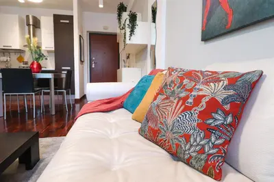 a living room with a white couch with colorful pillows at Margot - Quiet and Elegant with Free Parking in Rome