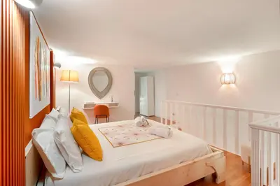 a white bedroom with a large bed with yellow pillows at Piazza Navona Suite - Pantheon in Rome