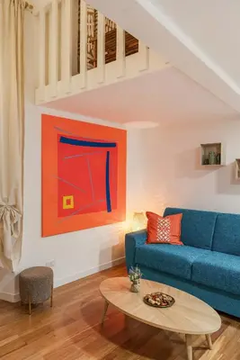 a living room with a blue couch and a painting at Piazza Navona Suite - Pantheon in Rome