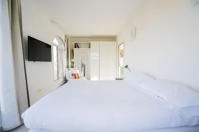 a large white bed in a room with a tv at St John Basilica Lovely Tower Apartment in Rome
