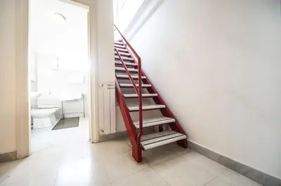 a red staircase in a room with a bathroom at St John Basilica Lovely Tower Apartment in Rome