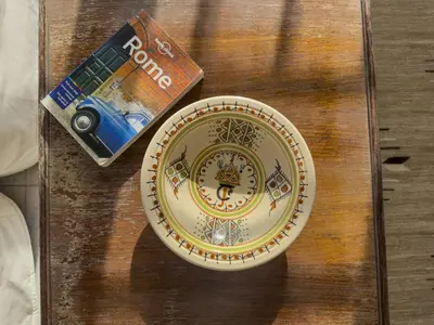 a plate and a book on a wooden table at St John Basilica Lovely Tower Apartment in Rome