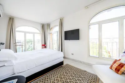 a white bedroom with two beds and a tv at St John Basilica Lovely Tower Apartment in Rome