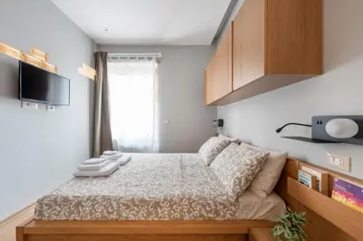 a small bedroom with a bed and a tv at Première in Rome