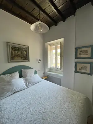 a bedroom with a bed with a white comforter at Al campanile Trastevere apartment in Rome