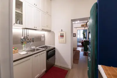 a kitchen with white cabinets and a sink and a stove at Al campanile Trastevere apartment in Rome
