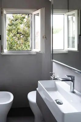 a bathroom with a sink and a toilet and a mirror at Al campanile Trastevere apartment in Rome
