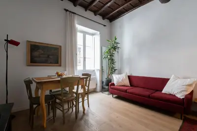 a living room with a red couch and a table at Al campanile Trastevere apartment in Rome