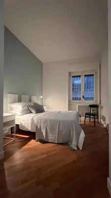 a bedroom with a bed and a desk and a window at Archimede 35 One step away from the center in Rome