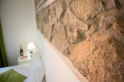 a brick wall next to a bed in a room at The Great Beauty in Rome