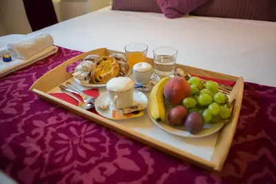 a tray of food with fruit and drinks on a bed at The Great Beauty in Rome