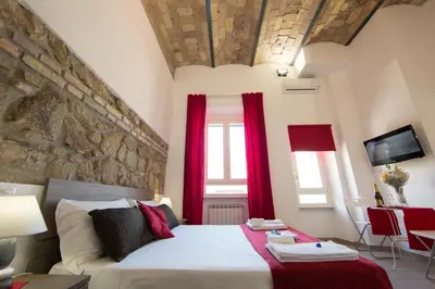 a bedroom with a large bed with red curtains at The Great Beauty in Rome
