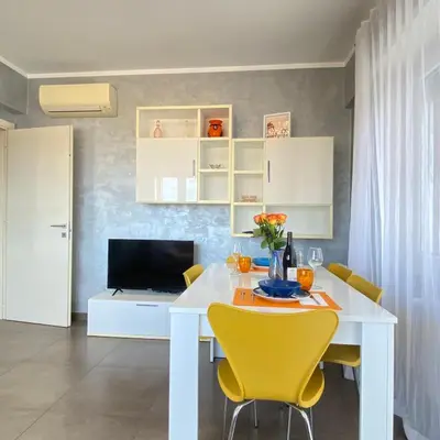 a dining room with a white table and yellow chairs at Casa Fontana - zona San Giovanni Colosseo in Rome
