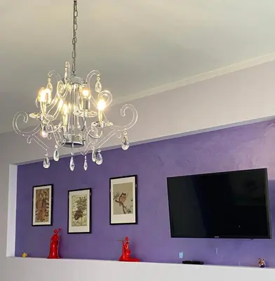 a chandelier in a living room with a purple wall at Casa Fontana - zona San Giovanni Colosseo in Rome