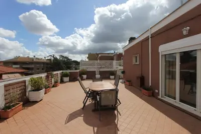 a patio with a table and chairs on a balcony at Pironti Flat in Rome